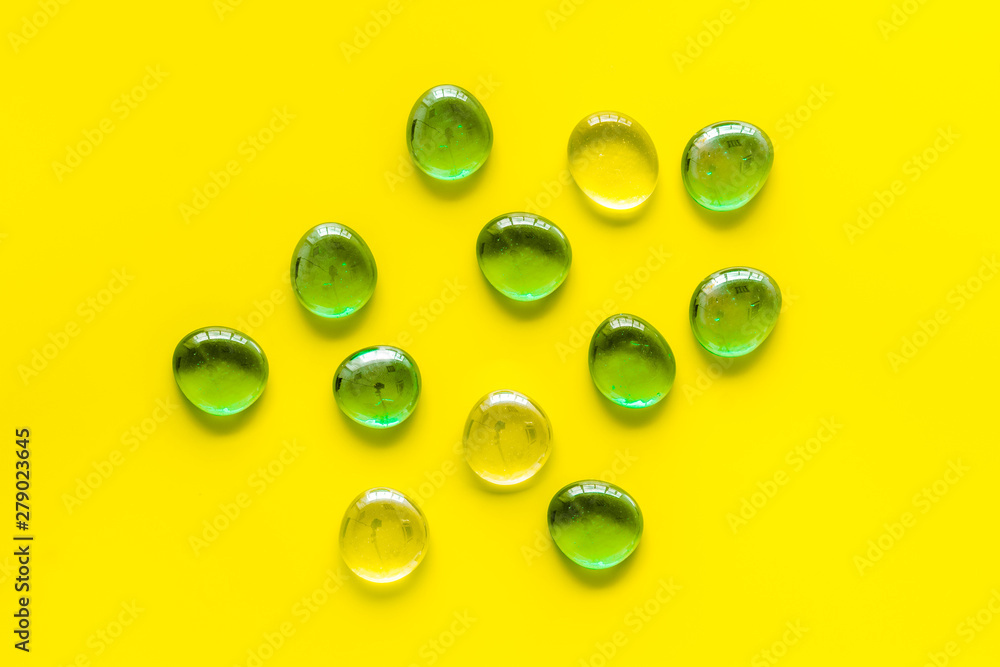 Glass stones for design and home creativity on yellow background top view Glass stones for design and home creativity on yellow background top view
