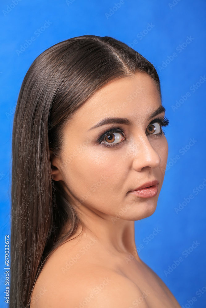 Beautiful young woman with eyelash extensions on color background Beautiful young woman with eyelash extensions on color background