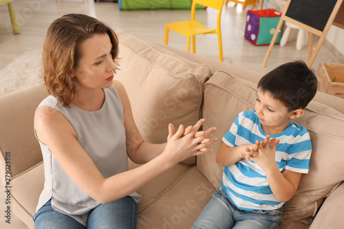 Female psychologist working with boy suffering from autistic disorder