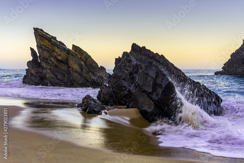 Rocky beach at sunrise, Adraga, Portugal. Travel and business background
