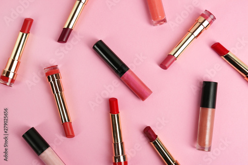 Set of bright lipsticks on pink background, flat lay