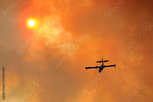 Canadair on the orange smoking sky