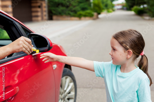 Stranger in the car offers candy to the child. Kids in danger. Children safety protection. Children kidnapping concept.  photo