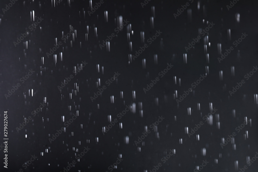 Rain drops falling down against dark background Rain drops falling down against dark background