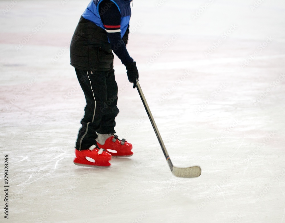 Obraz premium Young Child Playing Hockey on Ice