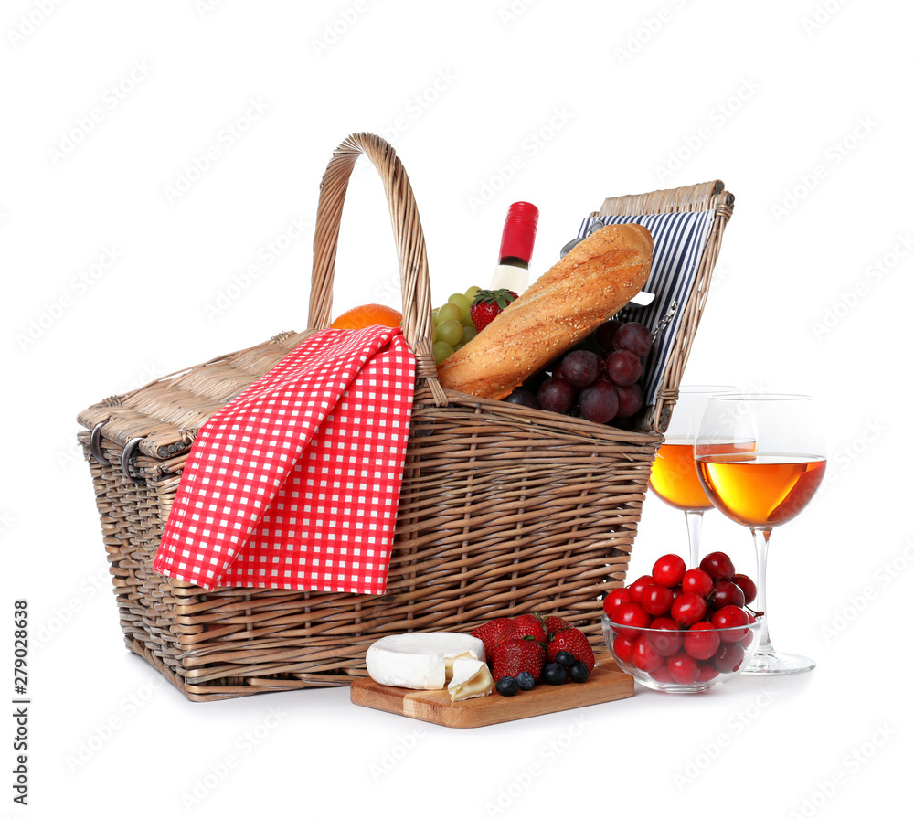 Wicker picnic basket with wine and different products on white background Wicker picnic basket with wine and different products on white background