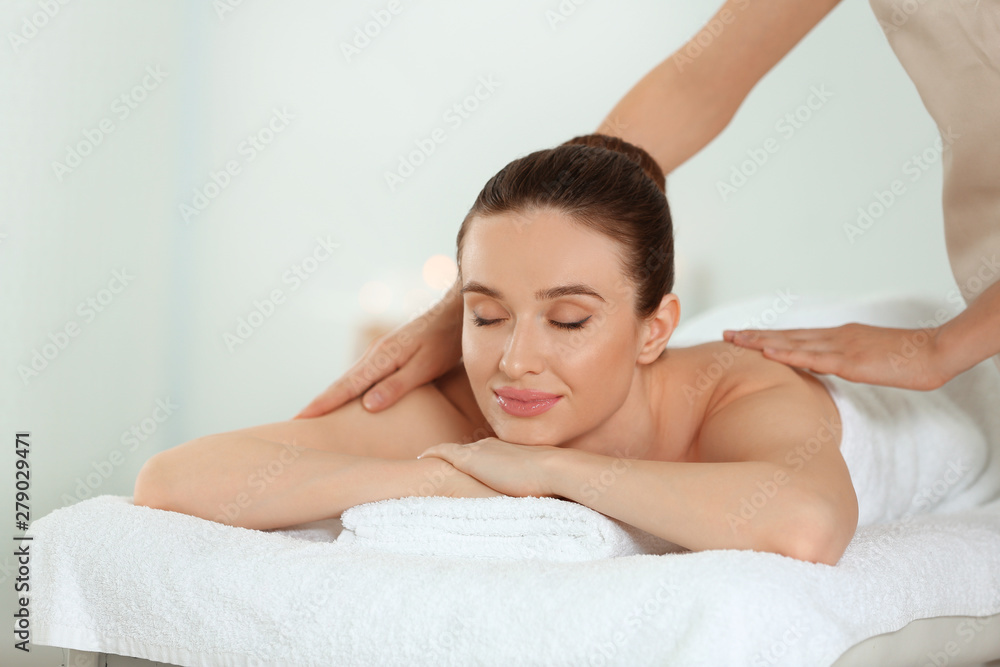 Beautiful young woman enjoying massage in spa salon Beautiful young woman enjoying massage in spa salon