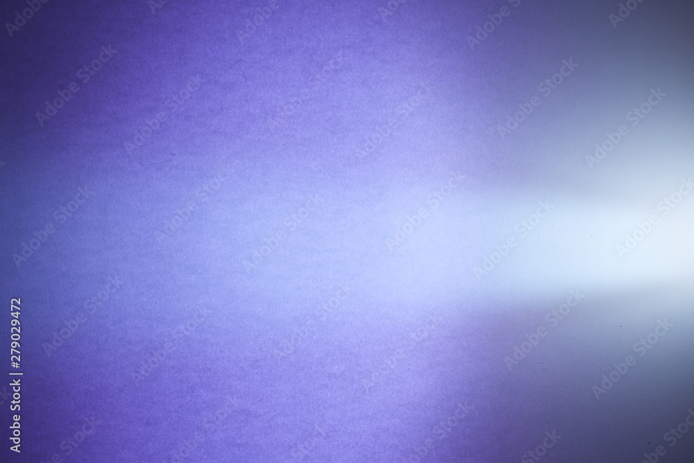 Obraz premium Cone-shaped light ray of light on a purple textural and half-blurred background