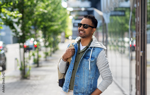 travel, tourism and lifestyle concept - smiling indian man in sunglasses with backpack on city street © Syda Productions