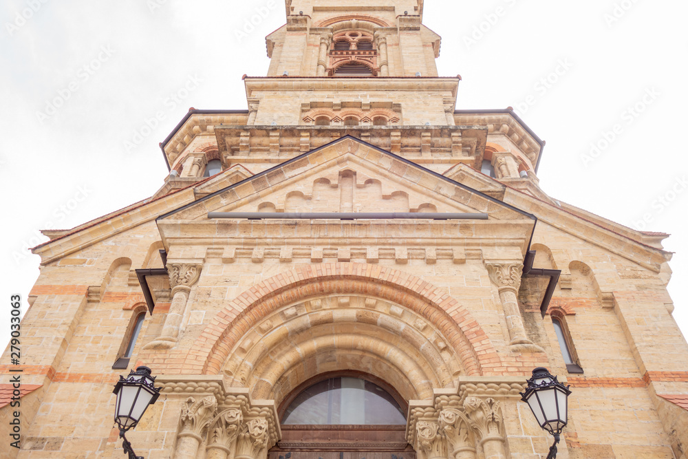 The building is made of natural sandstone. Facade of a catholic temple bottom view.