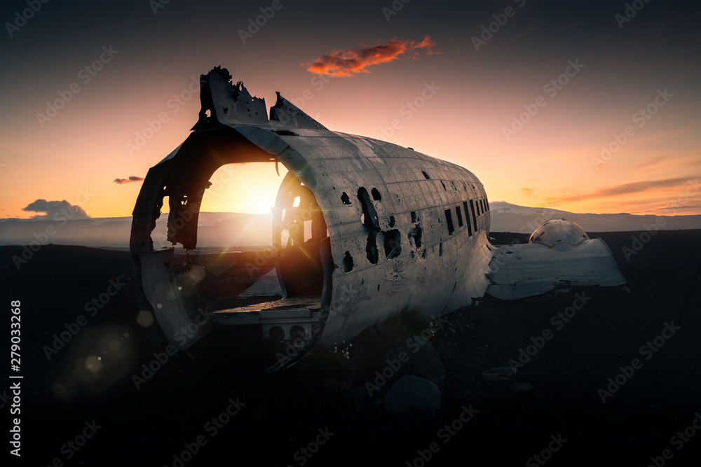 Crashed plane Dakota on black beach at the sunset