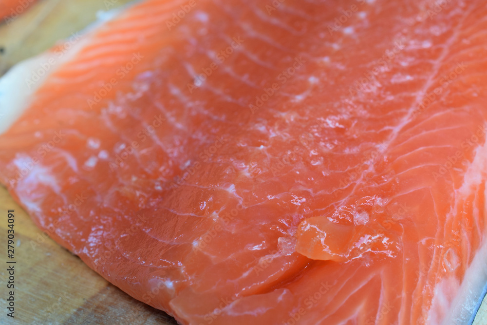 Fresh raw salmon on wooden cutting board. Shallow depth of field.