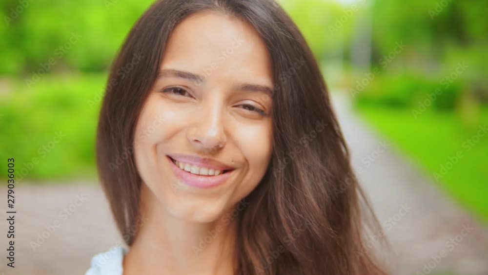 close up portrait laughing young caucasian woman in park with green nature on the background close up portrait laughing young caucasian woman in park with green nature on the background