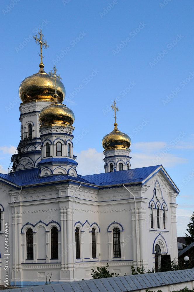 Orthodox Christian Cathedral with golden domes and crosses against the sky, spring day. Sobor Tikhvinskoy Ikony Bozhiyey Materi, Tsivilsk, Russia