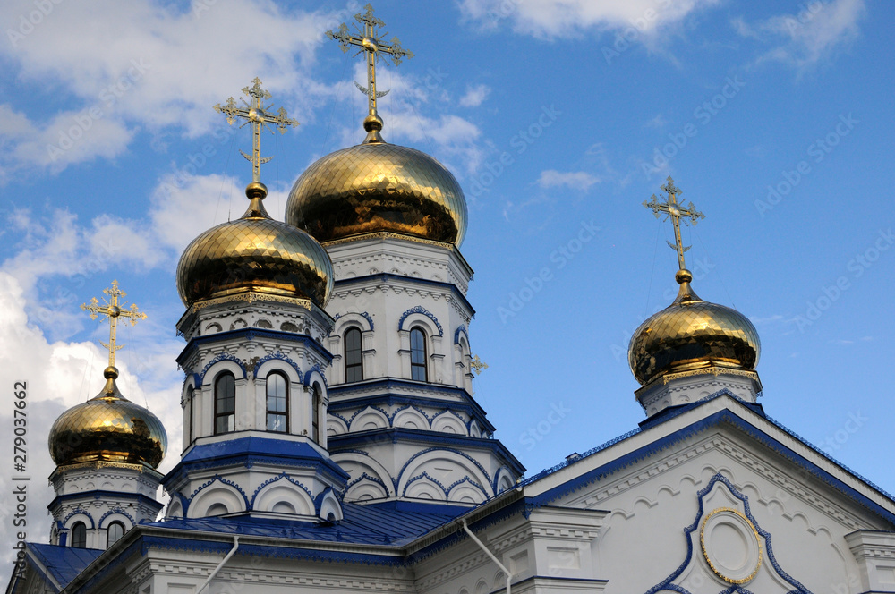 Orthodox Christian Cathedral with golden domes and crosses against the sky, spring day. Sobor Tikhvinskoy Ikony Bozhiyey Materi, Tsivilsk, Russia