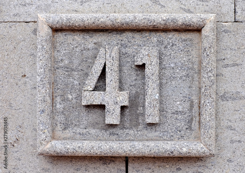 Number 41, forty-one, numeral on gray stone surface. © Daguimagery