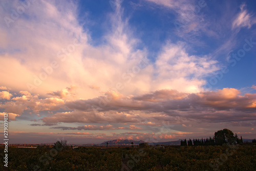 Sunset with clouds of evolution illuminated by the orange light of the sun