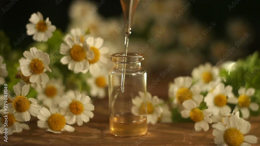 Essence of flowers on table in beautiful glass bottle Essence of flowers on table in beautiful glass bottle