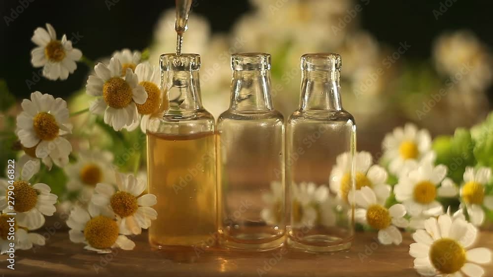Essence of flowers on table in beautiful glass bottle Essence of flowers on table in beautiful glass bottle