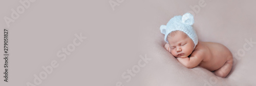 Portrait of cute ten days old newborn baby wearing bear bonnet with ears.