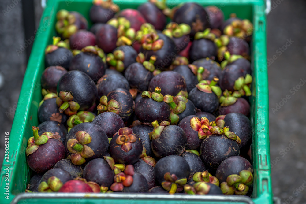 Fototapeta premium The blurred background of the fruit that is sold in the market (mangosteen). The fruit has dark brown-black color, small to large size, sweet taste, classified as a healthy alternative fruit.