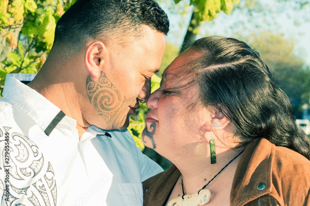 Portrait of an attractive Maori couple connected in a traditional hongi - obrazy, fototapety, plakaty 