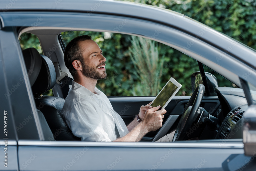 happy bearded man sitting in car and using digital tablet happy bearded man sitting in car and using digital tablet