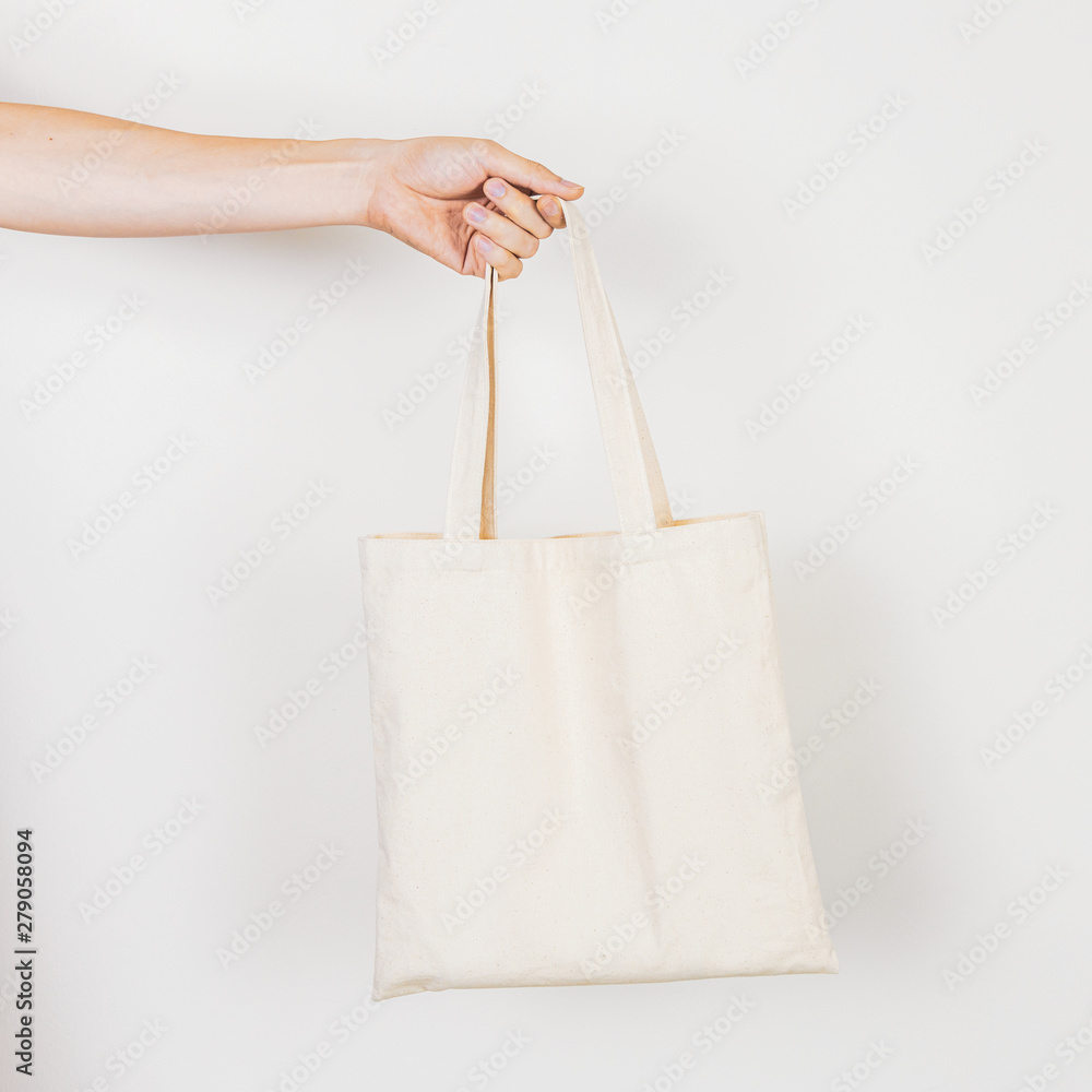 Hand holding empty, clean, eco-friendly tote bag for zero waste lifestyles  concept. Shot on white background. Stock Photo | Adobe Stock