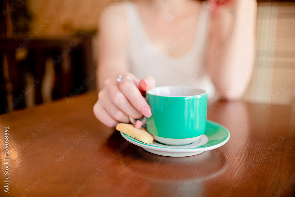 Female hands hold hot green coffee cup beverage, drinks cappuccino. Horizontal several objects copyspace Female hands hold hot green coffee cup beverage, drinks cappuccino. Horizontal several objects copyspace