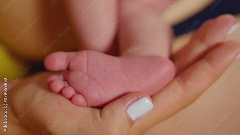 Baby feet in mother hands. Tiny Newborn Baby's feet on female Heart Shaped hands closeup. Mom and her Child. Happy Family concept. Beautiful conceptual video of Maternity. Close up shot. Baby feet in mother hands. Tiny Newborn Baby's feet on female Heart Shaped hands closeup. Mom and her Child. Happy Family concept. Beautiful conceptual video of Maternity. Close up shot.