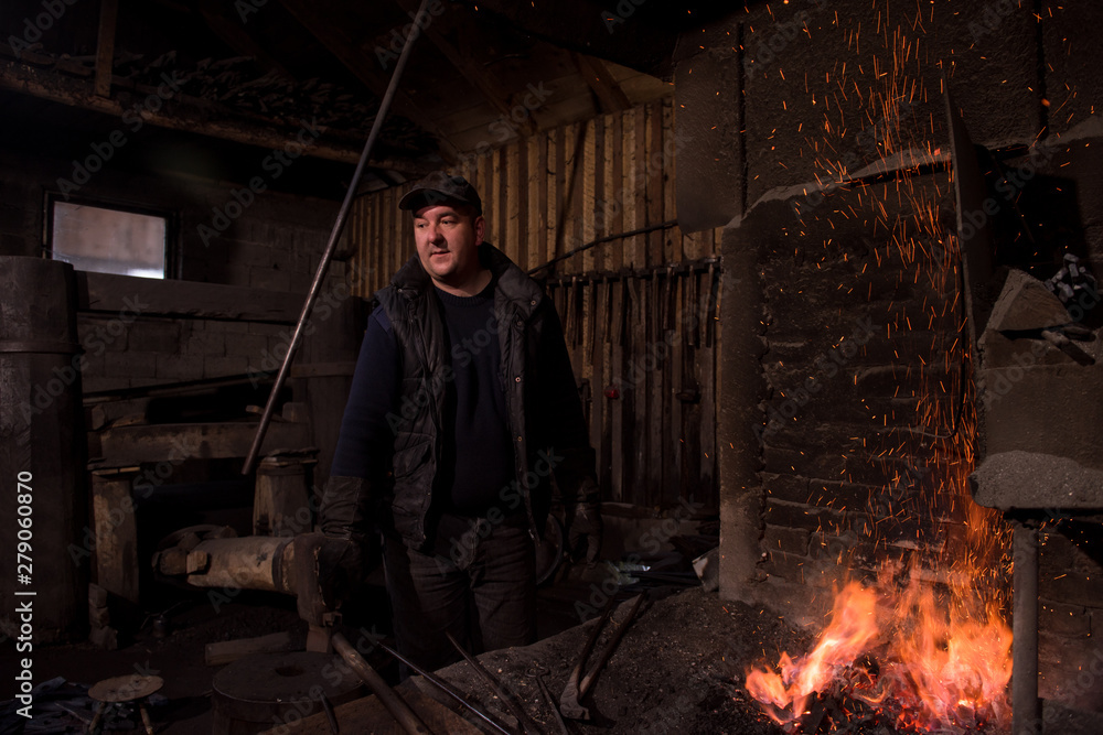 young traditional Blacksmith working with open fire young traditional Blacksmith working with open fire