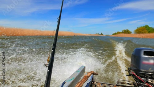 Hot spring on the Volga River. Russia, Astrakhan region, near the town of Kamyzyak. Fishing boat is on the river. View from the stern of the boat. photo