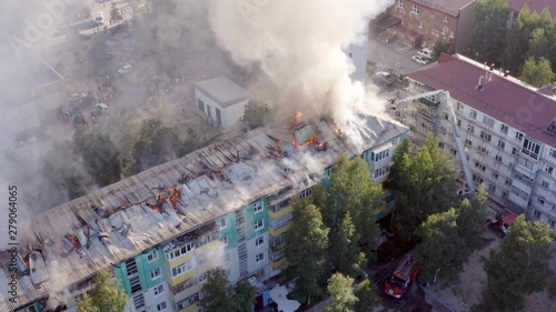 Burning roof of a residential high-rise building, clouds of smoke from the fire. top view