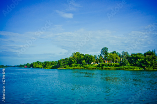 Green garden and blue sky by the river near Thai temple