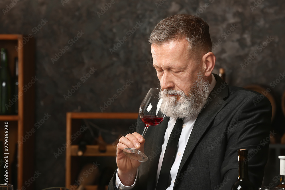 Mature sommelier working in wine cellar Mature sommelier working in wine cellar