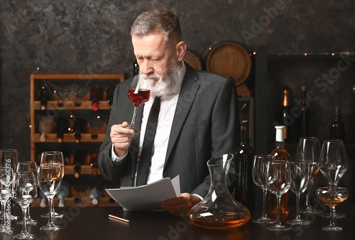 Mature sommelier working in...