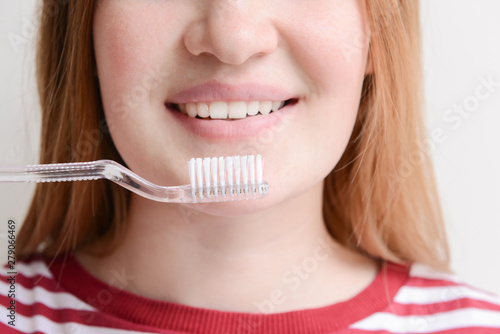 Woman with toothbrush on light background  closeup. Concept of dental hygiene