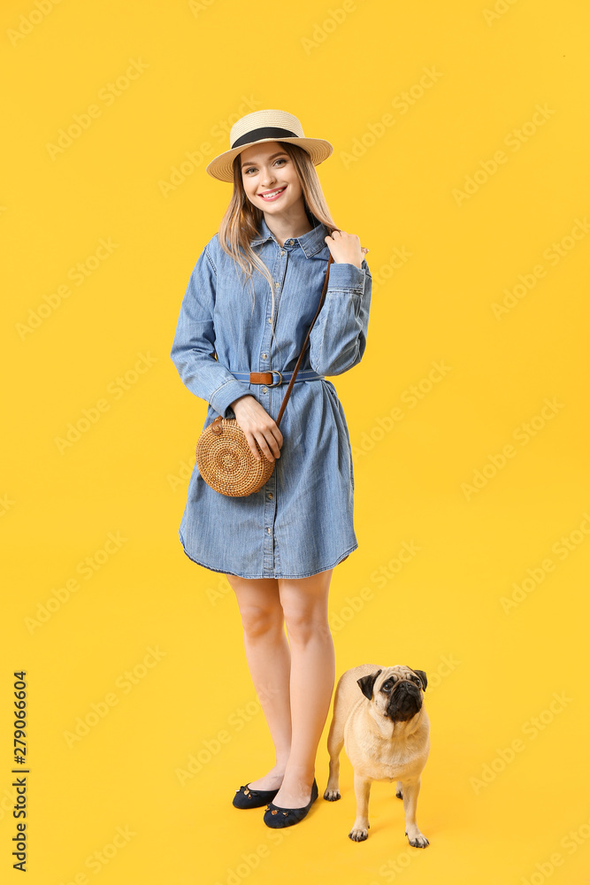 Fototapeta premium Beautiful young woman with cute pug dog on color background