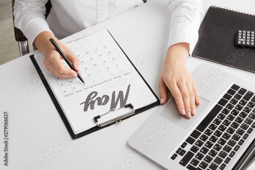 Young woman marking date in...