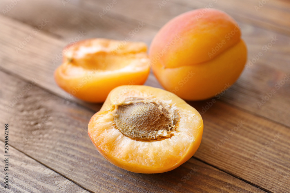 Tasty ripe apricots on wooden table, closeup
