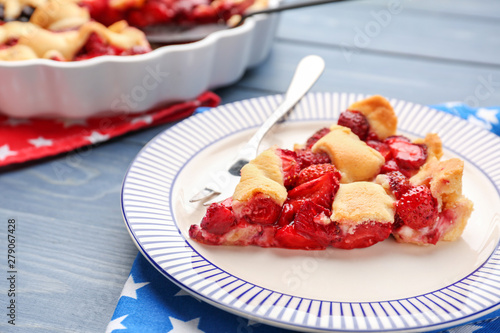 Plate with piece of tasty American flag pie on table