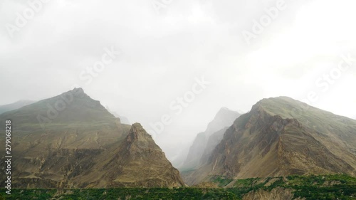 Timelapse of mountains and dense clouds with pouring rain. photo