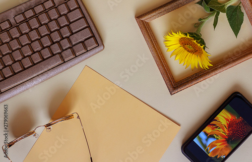 Office or school layouts on a light background. Keyboard, glasses, paper, sunflower and phone. On the screen of the phone is my picture IMG _5434. Back to school, concept. Top view, flat lay.