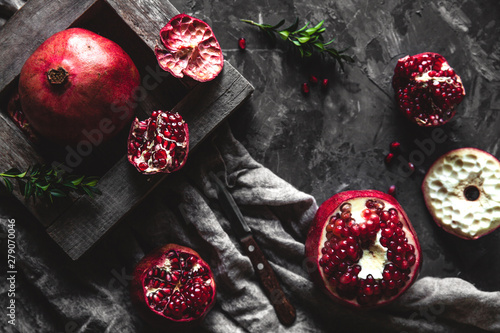 Fresh pomegranate in a wooden box. On a gray background. Top view. Copy space.