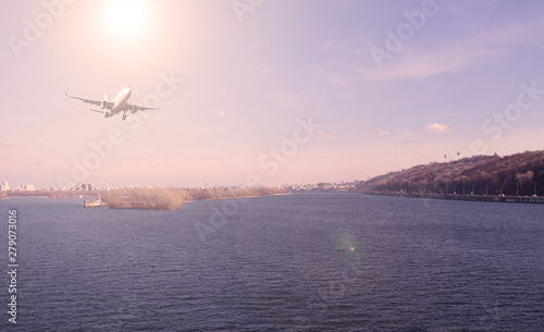 Airliner over the river in the city. Sunset. © YAROSLOVEPHOTOVIDEO