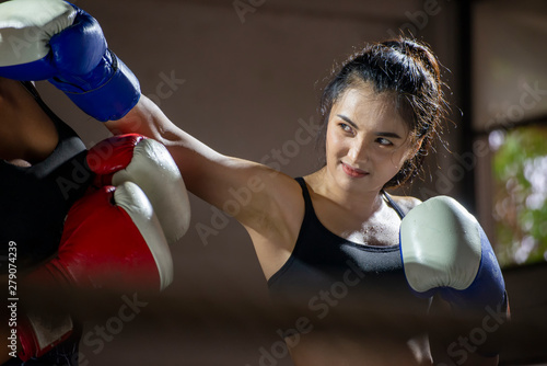 Boxing Woman prepare to trianing session and kickboxing,workout at thai boxing gym.Fit Female exercise hard to strengther muscle.Healthy concept. photo