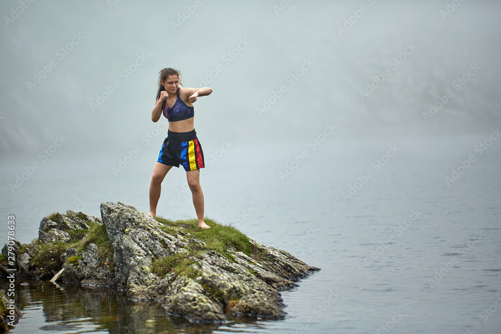 Woman kickbox fighter training by the lake Woman kickbox fighter training by the lake