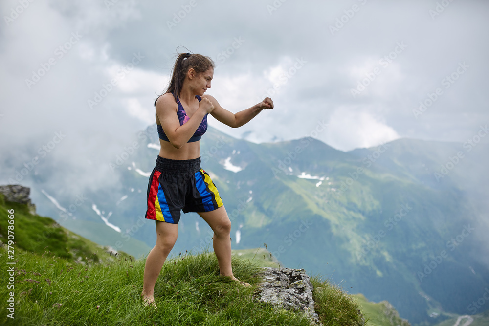 Naklejka premium Kickboxing girl on the mountains