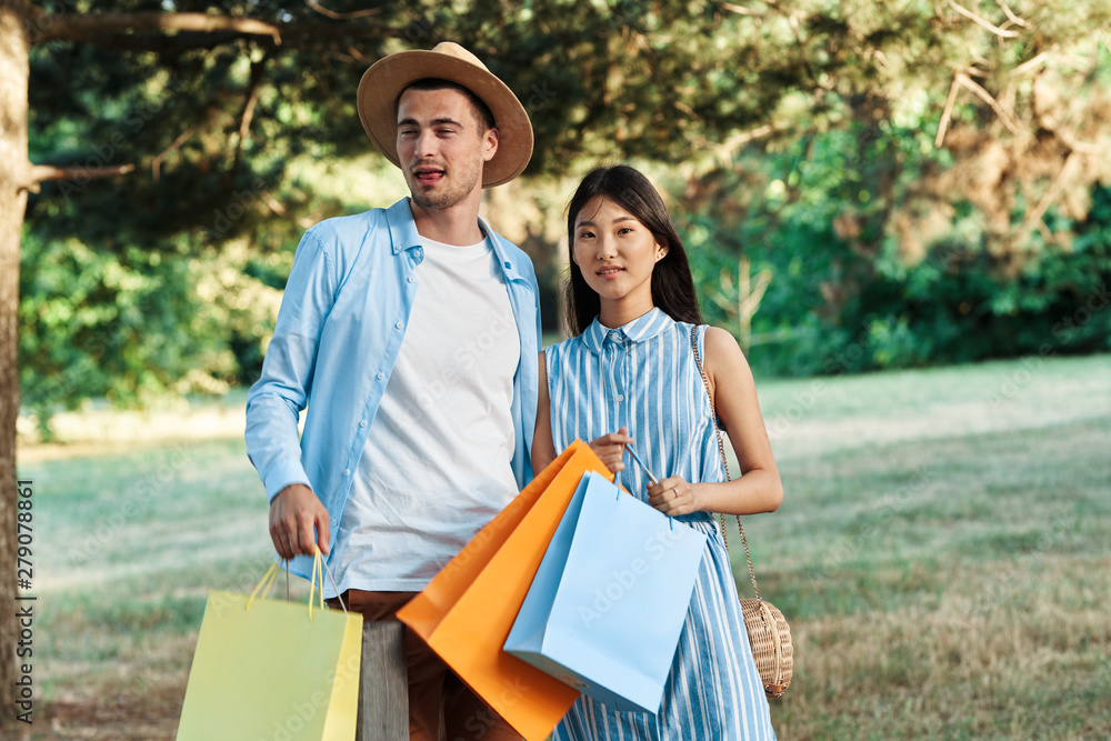 Naklejka premium happy young couple with shopping bags