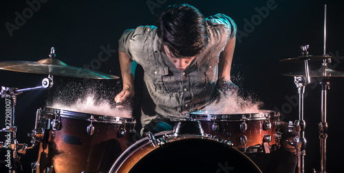 Sticker musician playing drums with splashes, black background with beautiful soft light